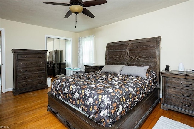 bedroom featuring baseboards, a closet, a ceiling fan, and wood finished floors