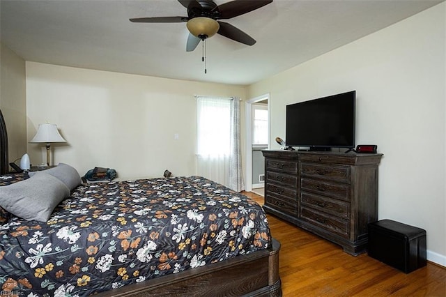 bedroom with wood finished floors, a ceiling fan, and baseboards