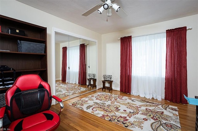 interior space featuring a ceiling fan, baseboards, and wood finished floors