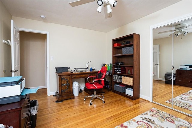 home office with a ceiling fan, baseboards, and wood finished floors