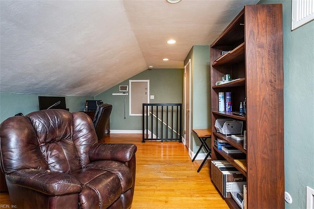 sitting room with light wood finished floors, baseboards, vaulted ceiling, an upstairs landing, and recessed lighting