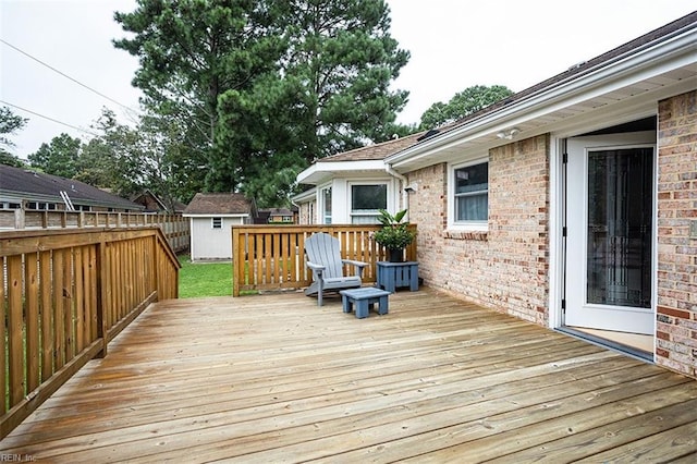 wooden deck with a shed, an outdoor structure, and fence