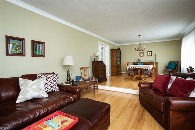 living room with ornamental molding, an inviting chandelier, and light wood-style floors