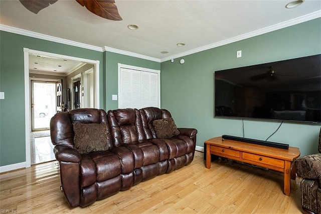 living area with ornamental molding, wood finished floors, and baseboards