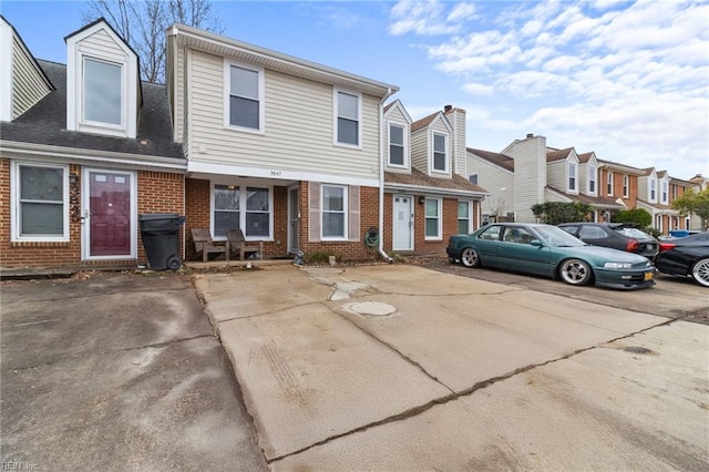 view of property with a residential view and brick siding