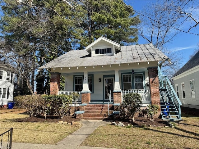 bungalow-style house featuring a porch and brick siding