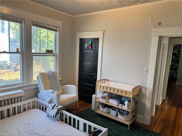 bedroom featuring baseboards, ornamental molding, and wood finished floors