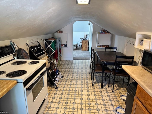 kitchen with light countertops, white electric range, stainless steel microwave, and lofted ceiling