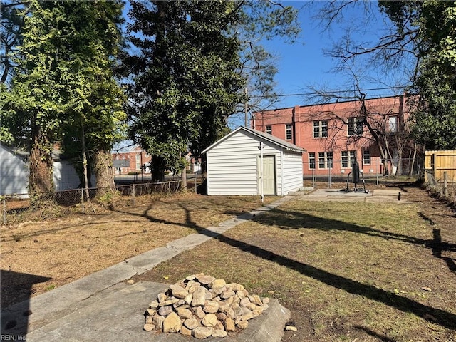 view of yard with a storage shed, a fenced backyard, and an outbuilding