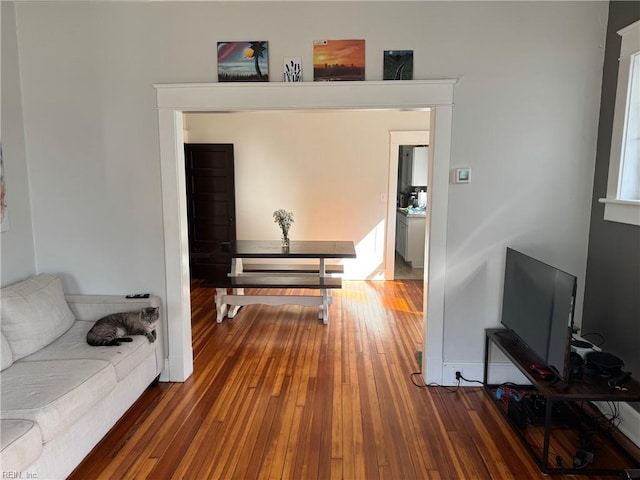 hall with wood-type flooring and baseboards