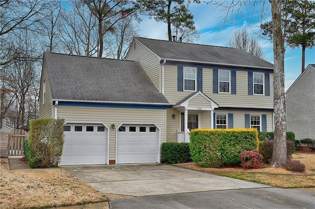 colonial-style house featuring a garage, concrete driveway, and a shingled roof