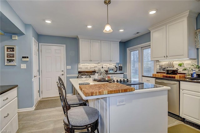 kitchen featuring a kitchen breakfast bar, stainless steel dishwasher, a kitchen island, and white cabinets