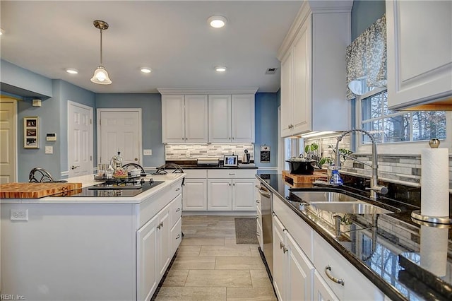 kitchen featuring dishwasher, a sink, black electric stovetop, white cabinetry, and backsplash