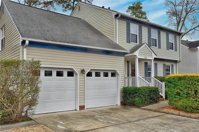 view of front of property featuring a garage, concrete driveway, and roof with shingles