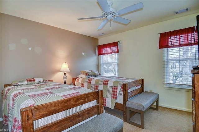 carpeted bedroom featuring baseboards, visible vents, and ceiling fan