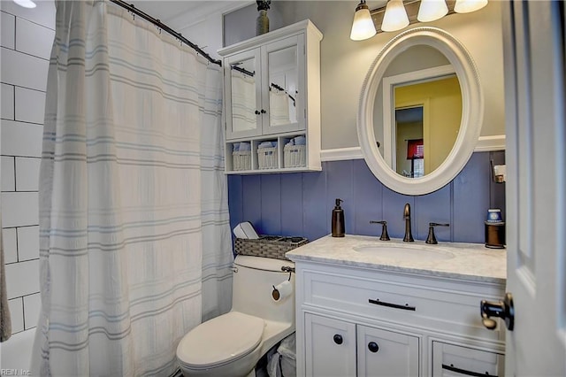 bathroom with toilet, a shower with shower curtain, and vanity