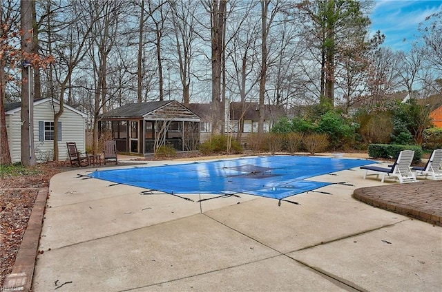 view of pool with a storage structure, a patio area, a fenced in pool, and an outdoor structure