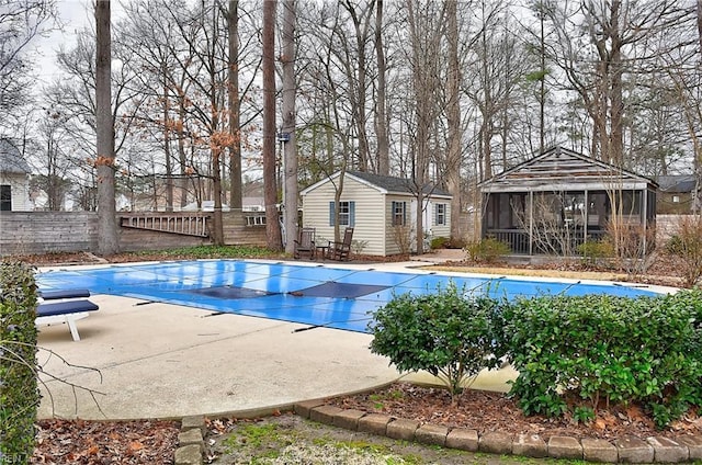 view of pool featuring a fenced in pool, a sunroom, an outbuilding, fence, and an exterior structure