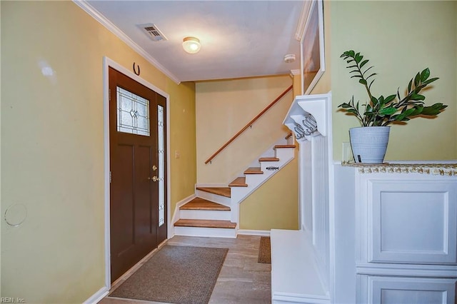 entrance foyer featuring crown molding, visible vents, wood finished floors, baseboards, and stairs