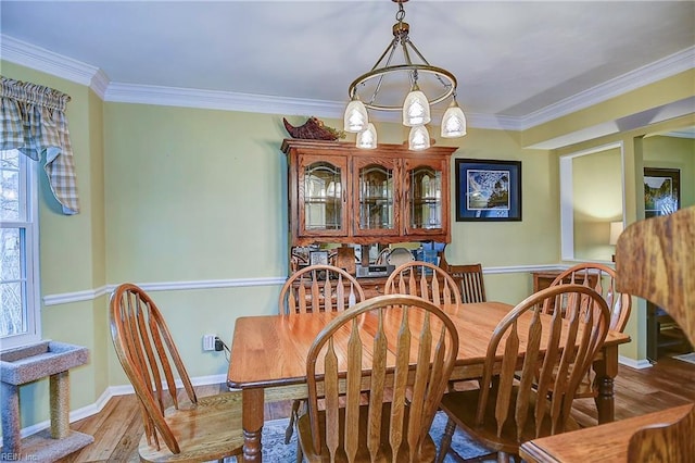 dining area featuring ornamental molding, wood finished floors, and baseboards