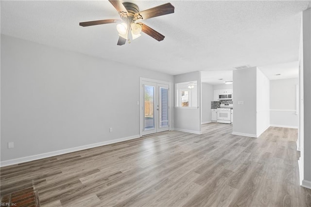 unfurnished living room featuring visible vents, baseboards, a ceiling fan, a textured ceiling, and light wood-type flooring