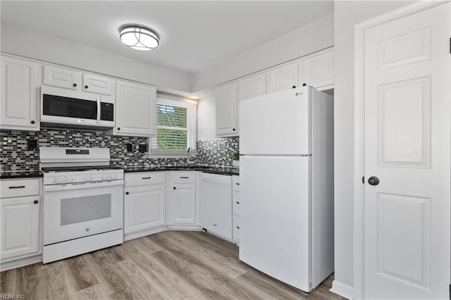 kitchen featuring dark countertops, white appliances, white cabinets, and light wood-style floors