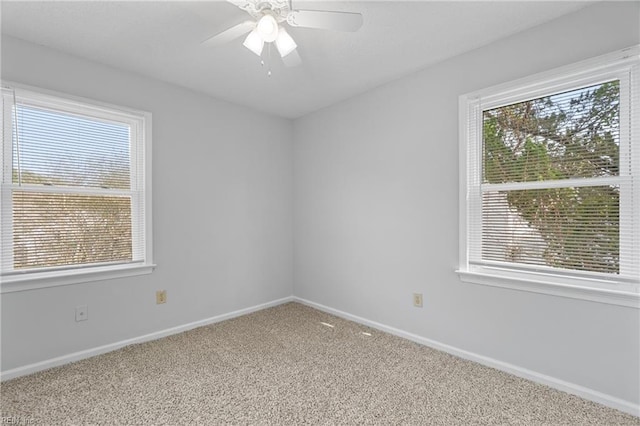 empty room featuring baseboards, carpet, a ceiling fan, and a healthy amount of sunlight