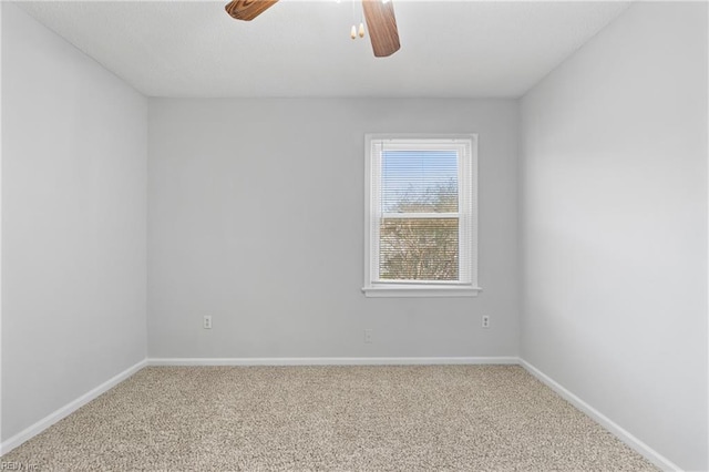 carpeted spare room with baseboards and a ceiling fan