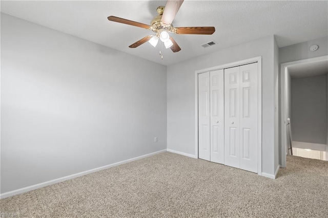 unfurnished bedroom with baseboards, a closet, visible vents, and carpet flooring