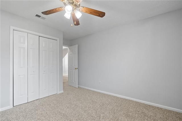 unfurnished bedroom featuring baseboards, a closet, visible vents, and carpet flooring