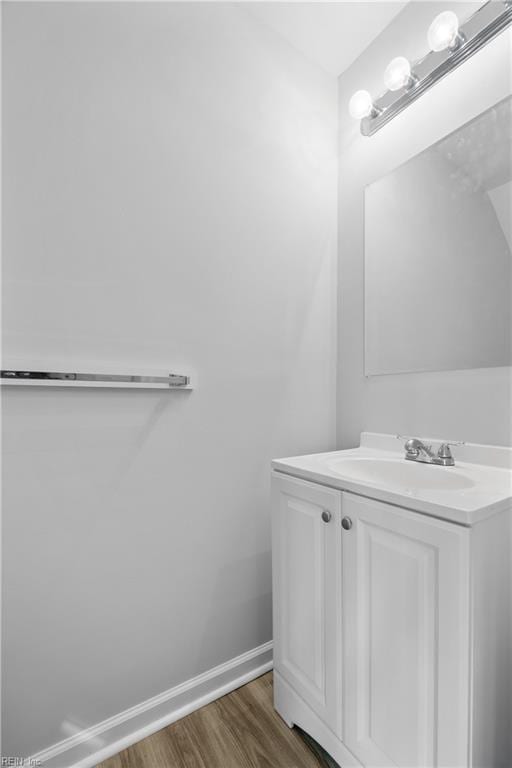 bathroom with vanity, baseboards, and wood finished floors