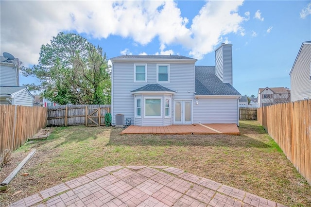 back of property featuring french doors, a fenced backyard, a chimney, and a wooden deck