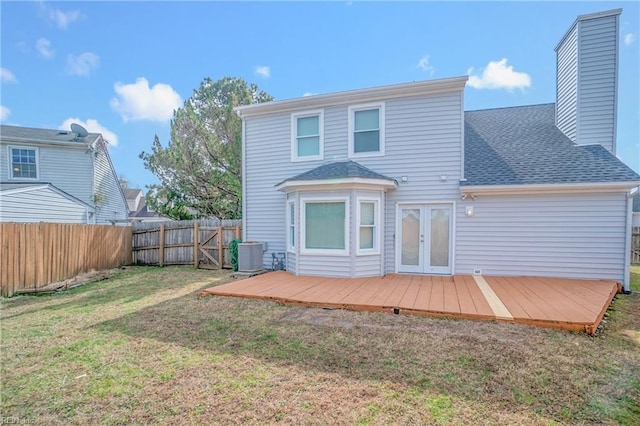 back of property with french doors, a yard, central air condition unit, a deck, and a fenced backyard