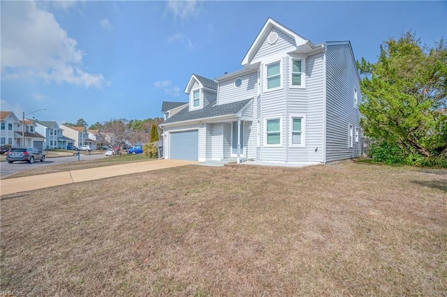 view of front of property with driveway, a front lawn, an attached garage, and a residential view