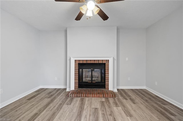 unfurnished living room with a fireplace, wood finished floors, and baseboards