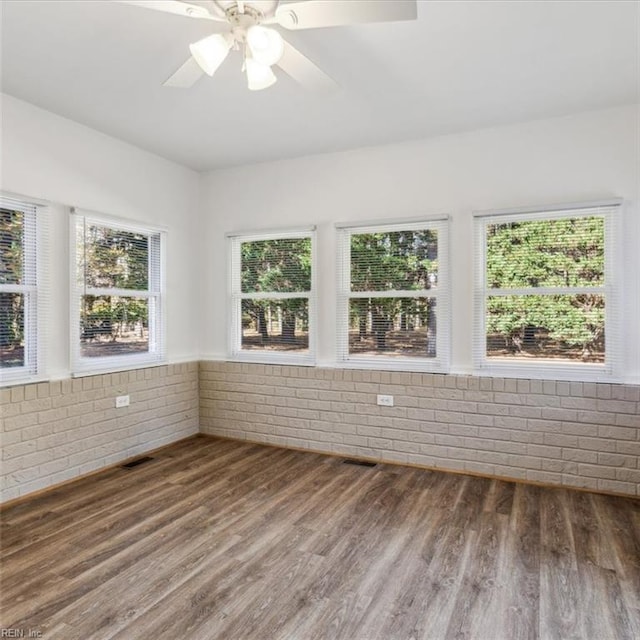 unfurnished sunroom featuring visible vents and a ceiling fan