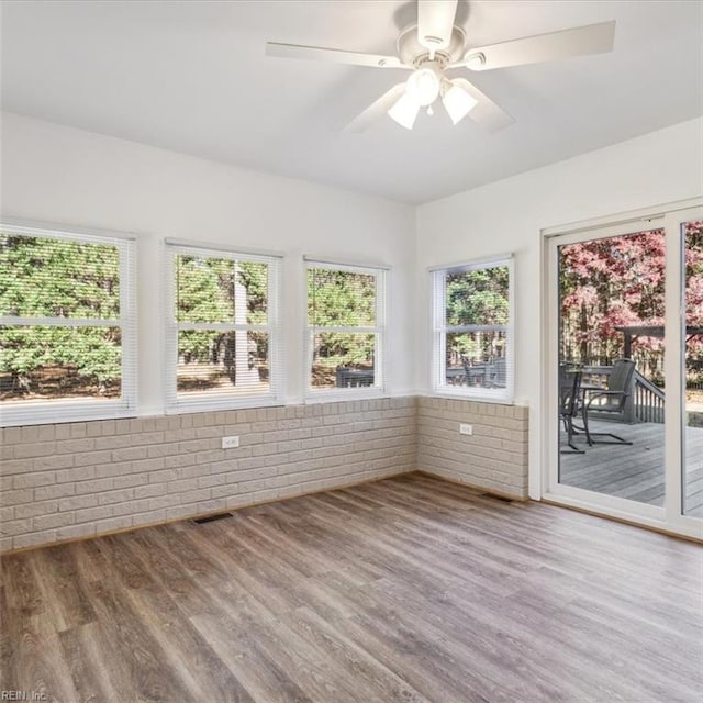 unfurnished sunroom featuring ceiling fan and visible vents