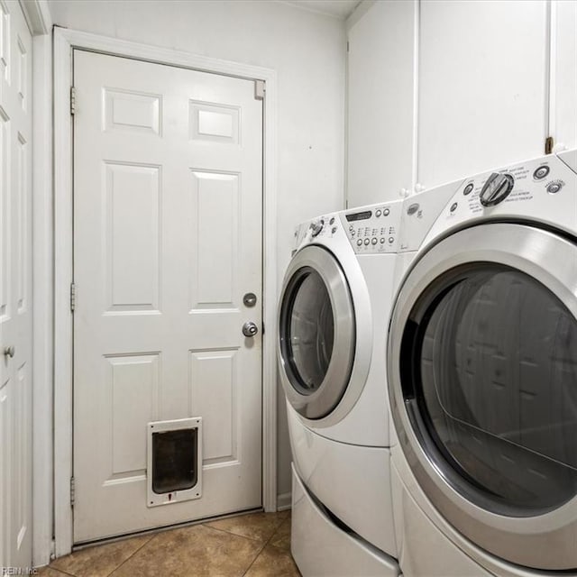 washroom featuring light tile patterned floors, laundry area, and washing machine and clothes dryer