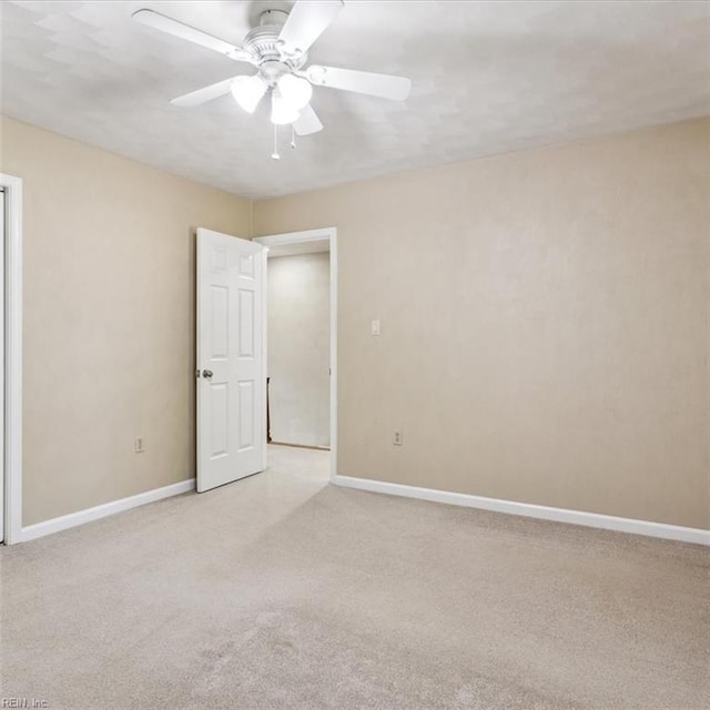 unfurnished room with light colored carpet, ceiling fan, and baseboards