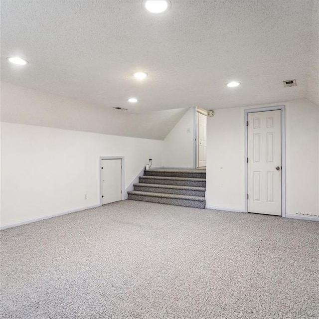 interior space with visible vents, carpet flooring, stairway, and a textured ceiling