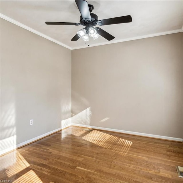 unfurnished room with a ceiling fan, baseboards, crown molding, and wood finished floors