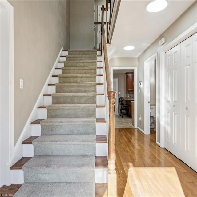 stairway featuring wood finished floors and baseboards