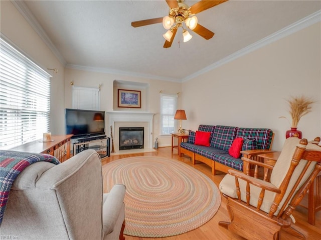 living area with plenty of natural light, crown molding, and wood finished floors