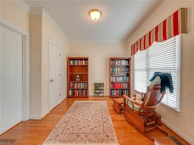 sitting room featuring light wood-type flooring, baseboards, and visible vents