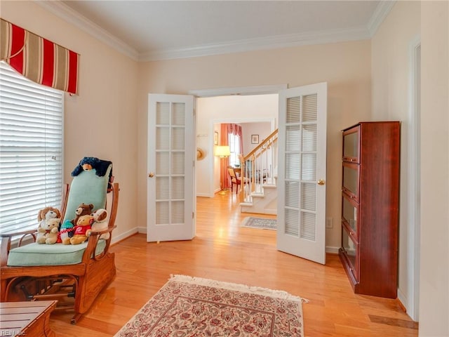 living area with light wood-type flooring, stairway, and ornamental molding