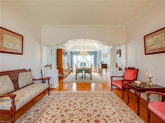 interior space featuring ornamental molding, arched walkways, decorative columns, and wood finished floors