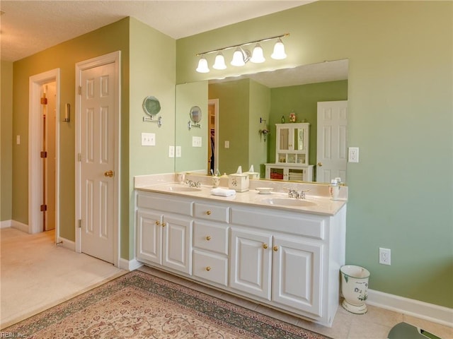 bathroom with a sink, baseboards, and double vanity