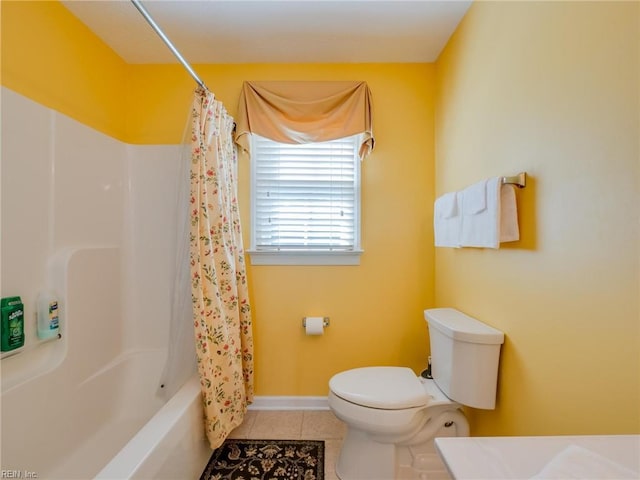 bathroom featuring baseboards, shower / tub combo, toilet, and tile patterned floors