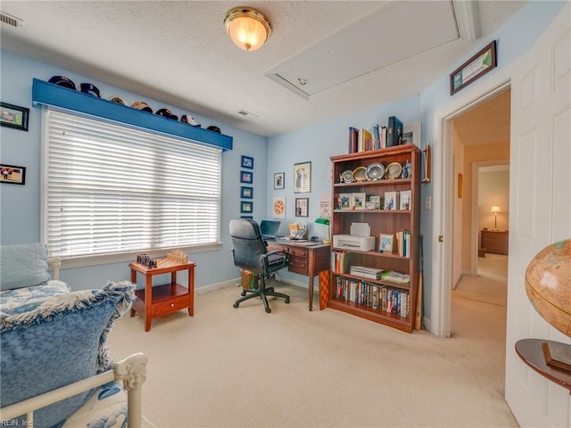 office area featuring attic access, visible vents, carpet flooring, and a textured ceiling