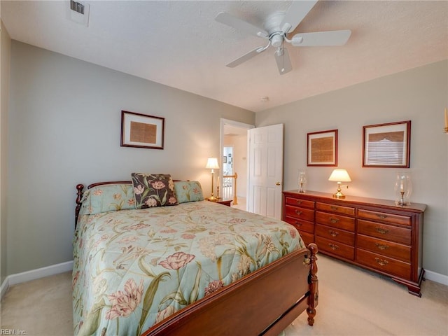 bedroom with a ceiling fan, visible vents, light carpet, and baseboards